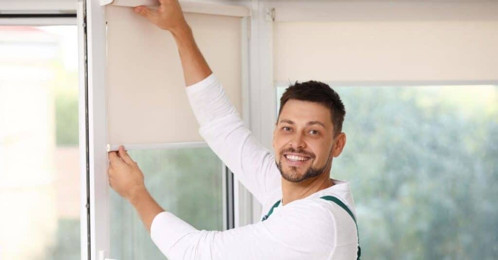 a man smiling at the camera, rendering professional window blind cleaning service