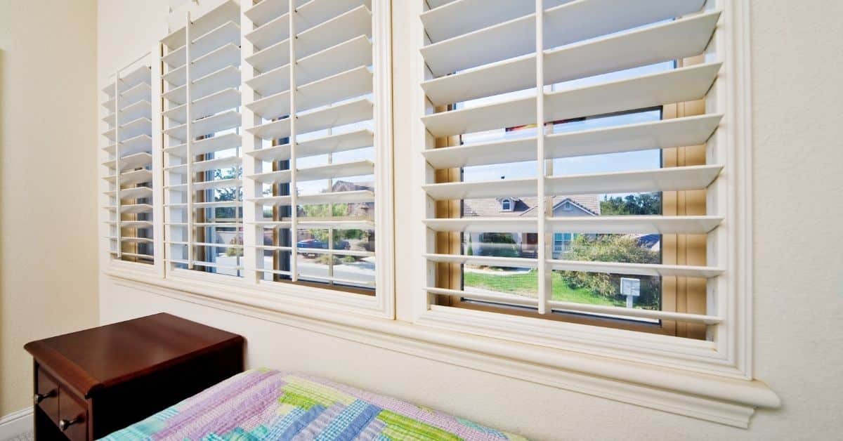 Bright white wood blinds cleaned and reinstalled in a Sacramento-area bedroom window